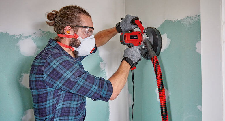 man using a wall and concrete grinder