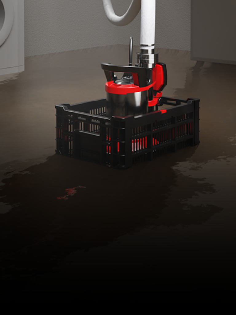 Das Bild zeigt einen überfluteten Hauswirtschaftsraum mit einer Schmutzwassertauchpumpe in einer schwarzen Kiste. Die Pumpe saugt aktiv Wasser ab und ist an einen Abflussschlauch angeschlossen. Im Hintergrund ist eine Waschmaschine zu sehen.