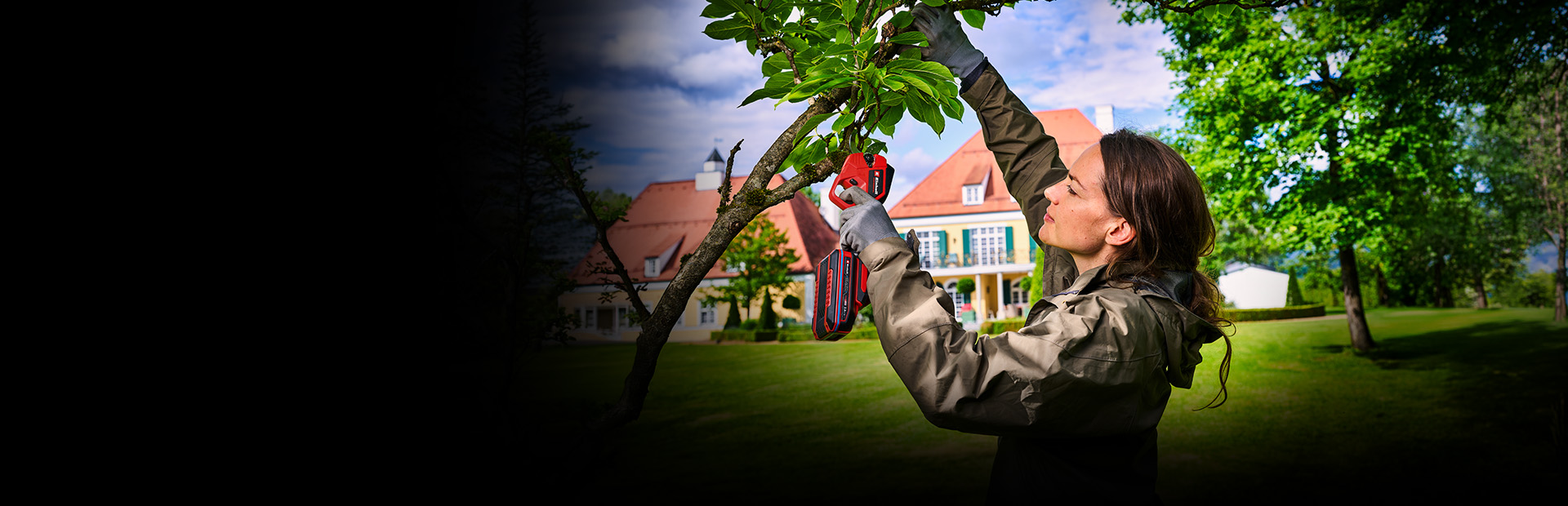 The banner shows a person using a cordless pruning tool from Einhell to cut a tree branch outdoors. The scene takes place in a green garden with a large house in the background and bright natural light. The focus is on the gardening activity and the tool in use.